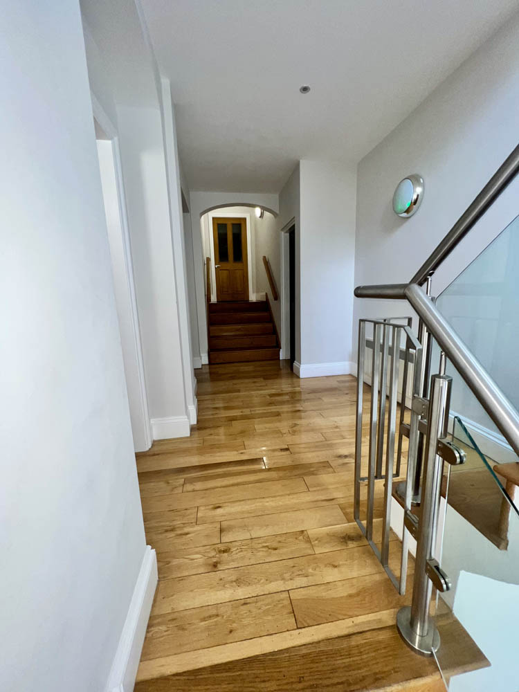 Internal hallway with wooden floor and white walls