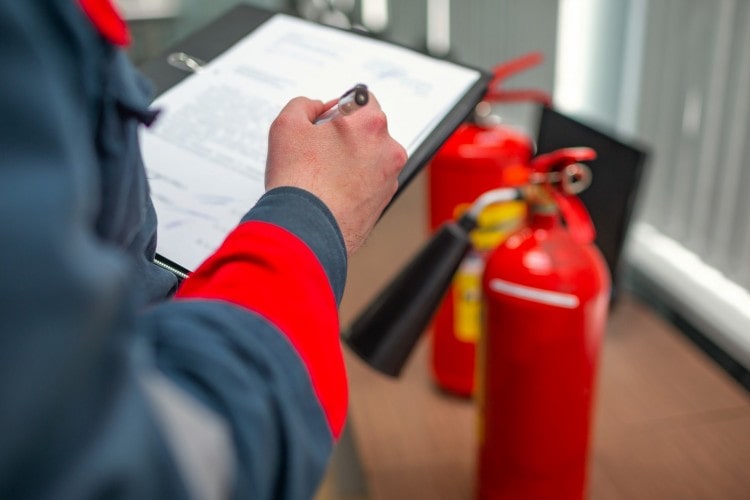 Clipboard with hand holding pen, 2 fire extinguishers